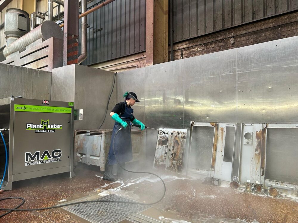 A worker using a MAC PlantMaster Electric to clean items used in the food and drink sector.