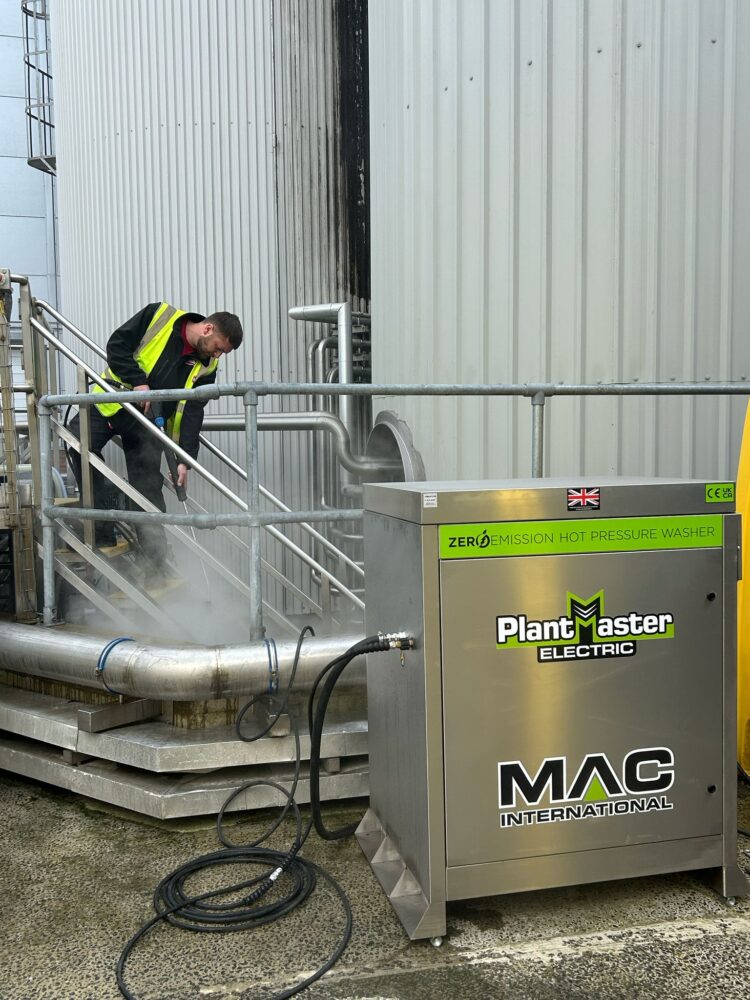 The MAC Plantmaster Electric pressure washer being used to clean a set of stairs in a facility.