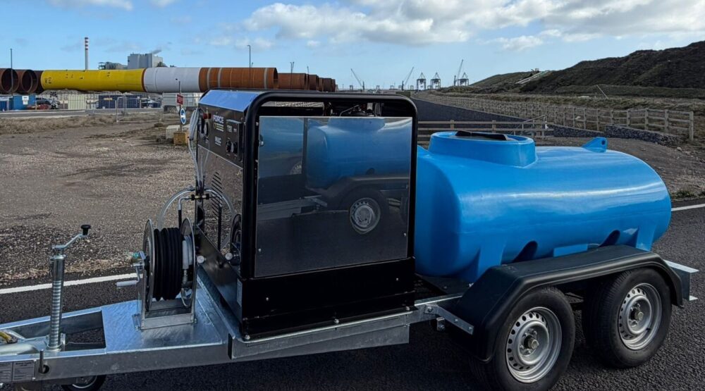 A pressure washer on the back of a trailer at a manufacturing facility.